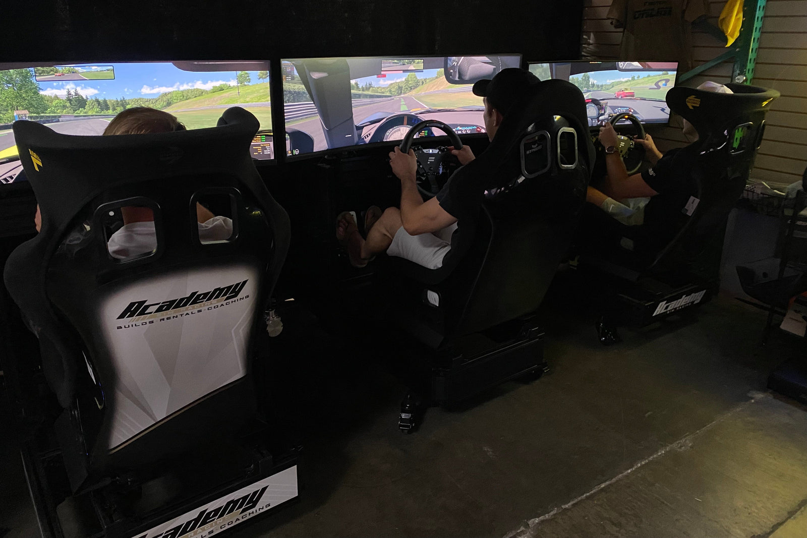 A group racing together on several Academy Sim Racing simulators at the Tampa sim lounge