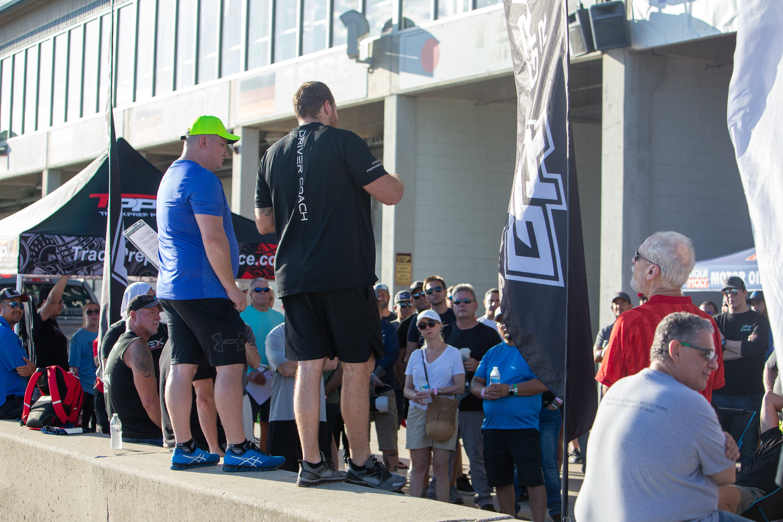 An Academy driver coach working with drivers in the paddock at a track day