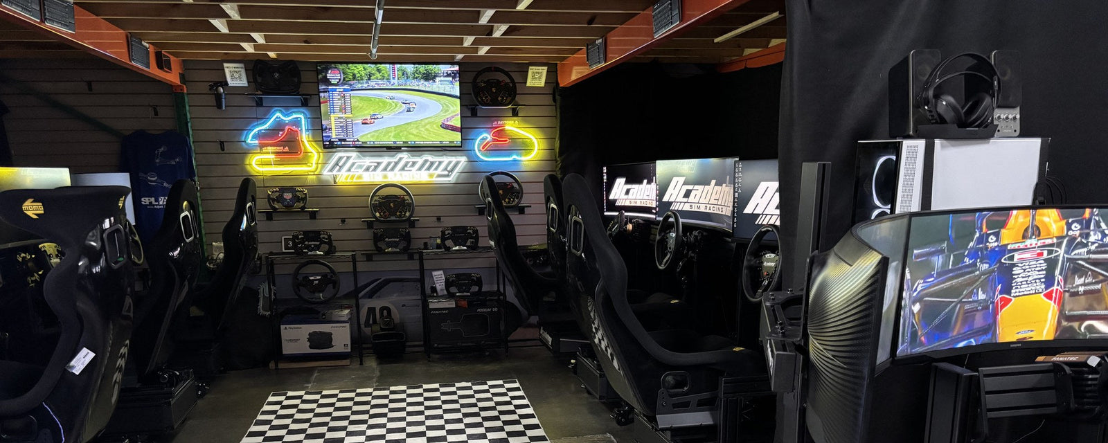 A wide view of the Academy Sim Racing lounge set up for a private group buyout in Tampa